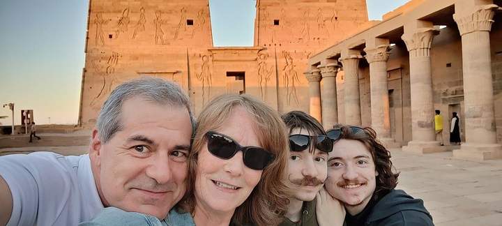 Familia tomándose un selfie ante el pilono iluminado por el sol del Templo de File, Asuán